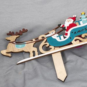 Vanerisessa kyltissä poron vetämä joulupukin reki lahjoineen